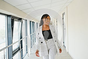 Young Businesswoman Standing In Corridor Of Modern Office Building