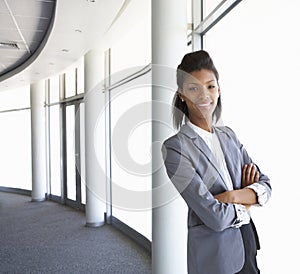 Young Businesswoman Standing In Corridor Of Modern Office Building