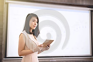 Young businesswoman standing and presenting in the meeting room