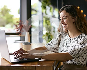 Young Businesswoman With Takeaway Coffee Working Sitting On Laptop In Coffee Shop Or Office