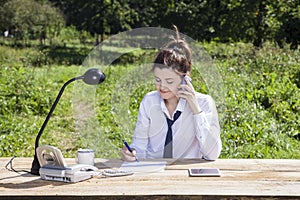 Young businesswoman taking notes while talking