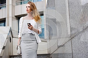 Young businesswoman talking on cellphone while walking outdoor