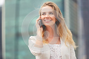 Young businesswoman talking on cellphone while walking outdoor