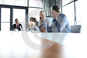 Young businesswoman talking with male colleague in meeting room