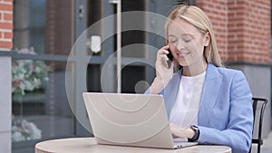 Young Businesswoman Talking on Phone, Sitting Outdoor