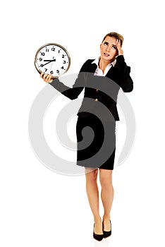 Young businesswoman terrified looks at the clock
