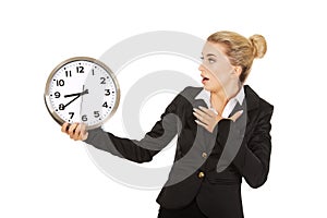 Young businesswoman terrified looks at the clock