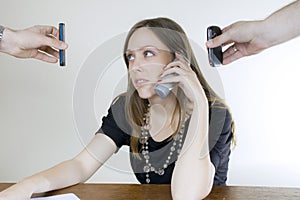 Young businesswoman with three cellphones