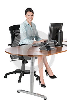 Young businesswoman typing at computer, isolated