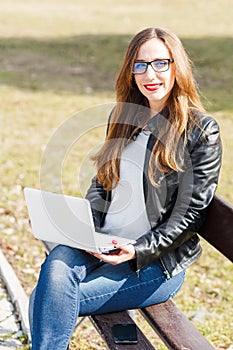 Young businesswoman use laptop sitting in the park