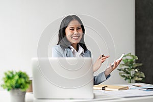 Young businesswoman using a calculator to calculate business principles. Accounting statistics concept at the office