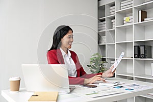 Young businesswoman using a calculator to calculate business principles. Accounting statistics concept at the office