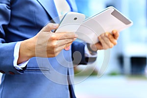 Young businesswoman using digital tablet and mobile phone