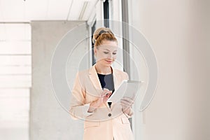 Young businesswoman using digital tablet in new office