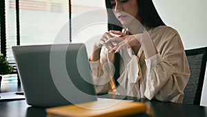 Young businesswoman using laptop and working with financial document at contemporary workplace