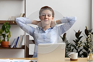 Young businesswoman visualizing dreams with eyes closed in office photo