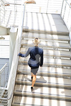 Young businesswoman walking on stairs