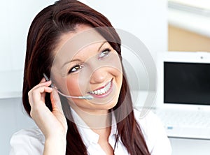 Young businesswoman wearing earpiece in her office