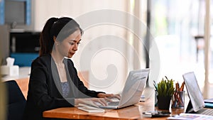 Young businesswoman working on her project with laptop computer while sitting a office desk.
