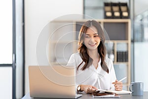 Young businesswoman working on laptop in office