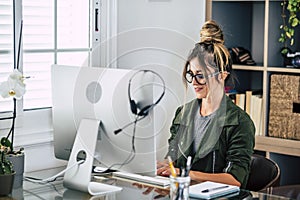 Young businesswoman write on laptop computer at home in smart working office job work activity - remote worker lifestyle concept