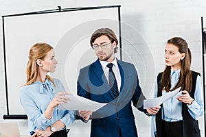 young businesswomen showing papers to their boss