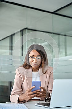 Young busy African American business woman using mobile phone in office.