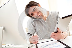 Young busy men at the office using tablet and smartphone