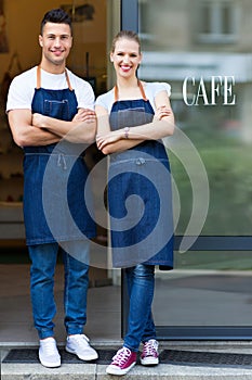 Young cafe owners in doorway