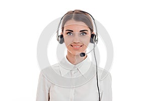 young call center office girl with headphones and microphone looking at the camera and smiling isolated on white