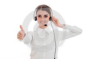 young call center office girl with headphones and microphone looking at the camera smiling and showing thumbs up