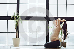 Sport and pregnancy. Young calm pregnant woman preparing for yoga or stretching practice at home