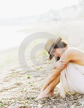 Young calm woman relax sitting on a sand sea beach, romantic foggy morning.