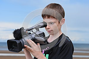 Young cameraman at the beach