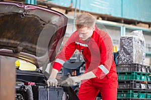 Young car mechanic in repair garage, Technician man working in auto repair shop, Car repair and maintenance concepts