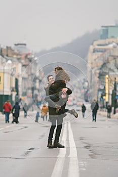 Young carefree happy people. Caucasian young students. Guy and girl. Love. Walk together on the european street in winter road.
