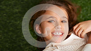 Young and carefree. High angle portrait of a cute little girl lying on her back on the grass.