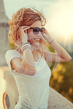 Young carefree tourist woman in sunglasses and toothy smile enjoying the view