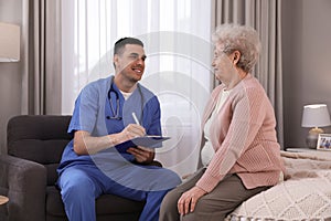 Young caregiver examining senior woman. Home health care service