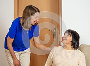 Young caregiver helping senior woman at home. Caring nurse assisting her middle aged female patient.