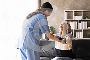 Young caregiver helping senior woman walking. Nurse assisting her old woman patient at nursing home. Senior woman with