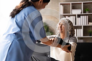 Young caregiver helping senior woman walking. Nurse assisting her old woman patient at nursing home. Senior woman with