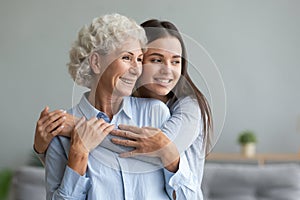 Young caring grand daughter hugs loving elderly grandmother photo