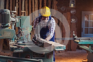 Carpenter doing his job in carpentry workshop.