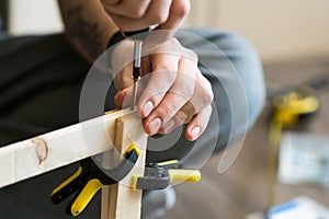 Young carpenter, handyman working with wood, using a screwdriver