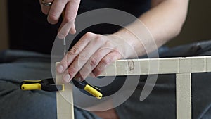 Young carpenter, handyman working with wood, using a screwdriver