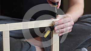 Young carpenter, handyman working with wood, using a screwdriver