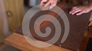 Young carpenter sanding wood in workshop