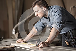 Young carpenter using measuring tape