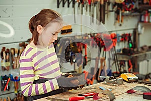 Young carpenter working in craft workshop. Creative student doing his project in workshop. Boy in the workshop makes crafts with